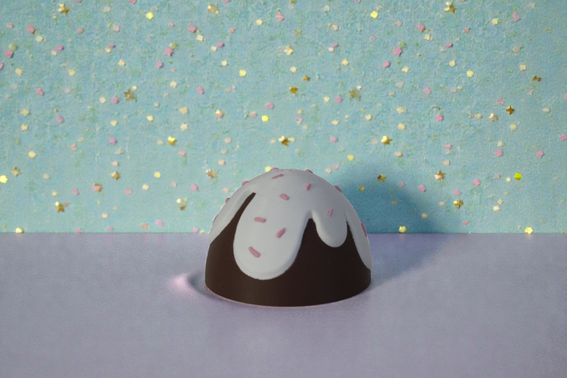 3D printed chocolate glaze egg container top, brown PLA dome with white drip icing detail and pink sprinkle accents, decorative Easter collectible lid.