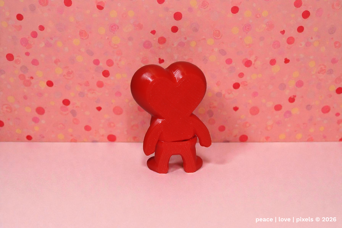 3D printed, red, heart-shaped, articulated figure on a pink background with polka dots. Designer: ZOU3D. peace | love | pixels is an authorized seller for ZOU3D. https://www.instagram.com/zou3d