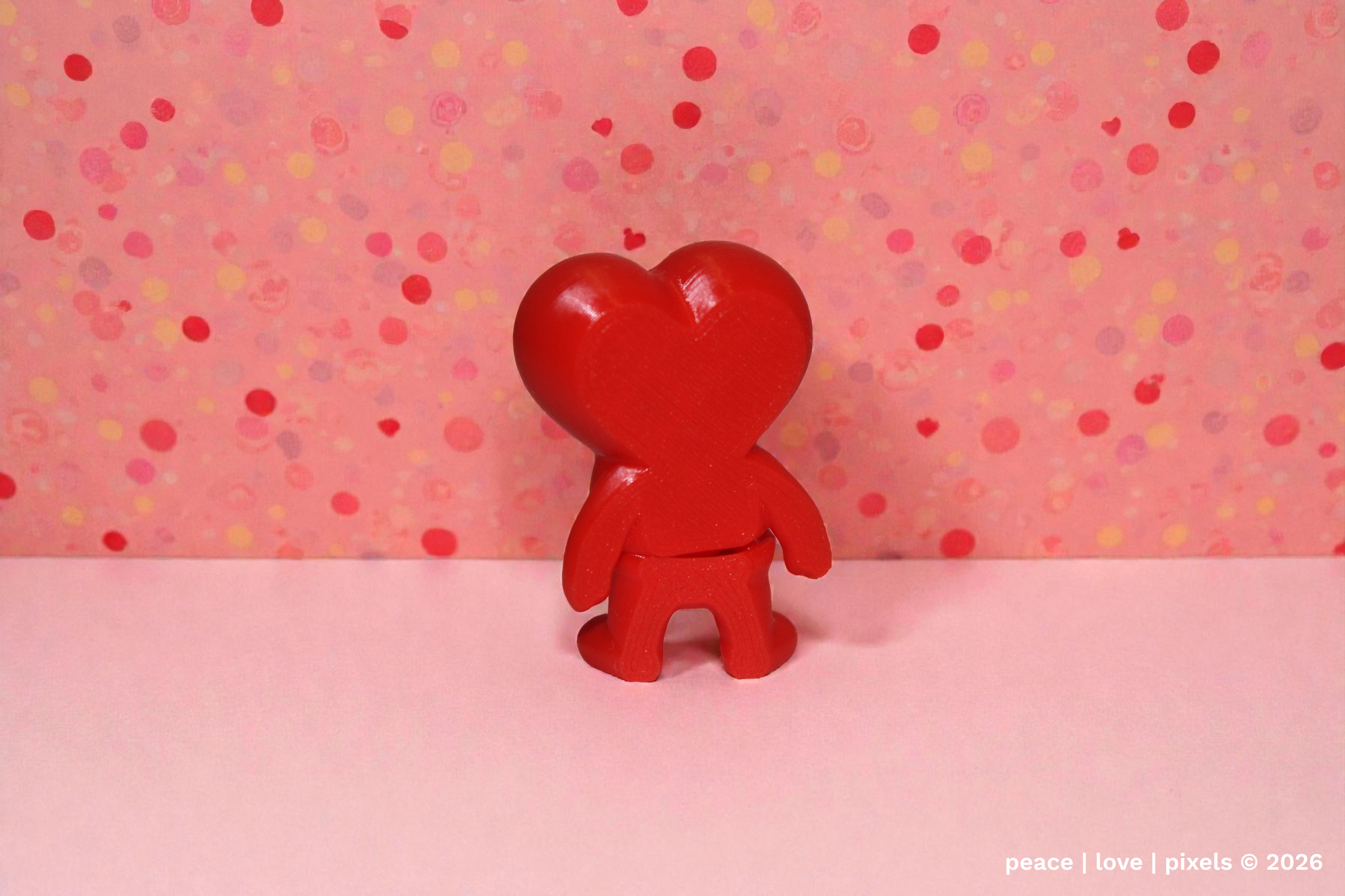 3D printed, red, heart-shaped, articulated figure on a pink background with polka dots. Designer: ZOU3D. peace | love | pixels is an authorized seller for ZOU3D. https://www.instagram.com/zou3d