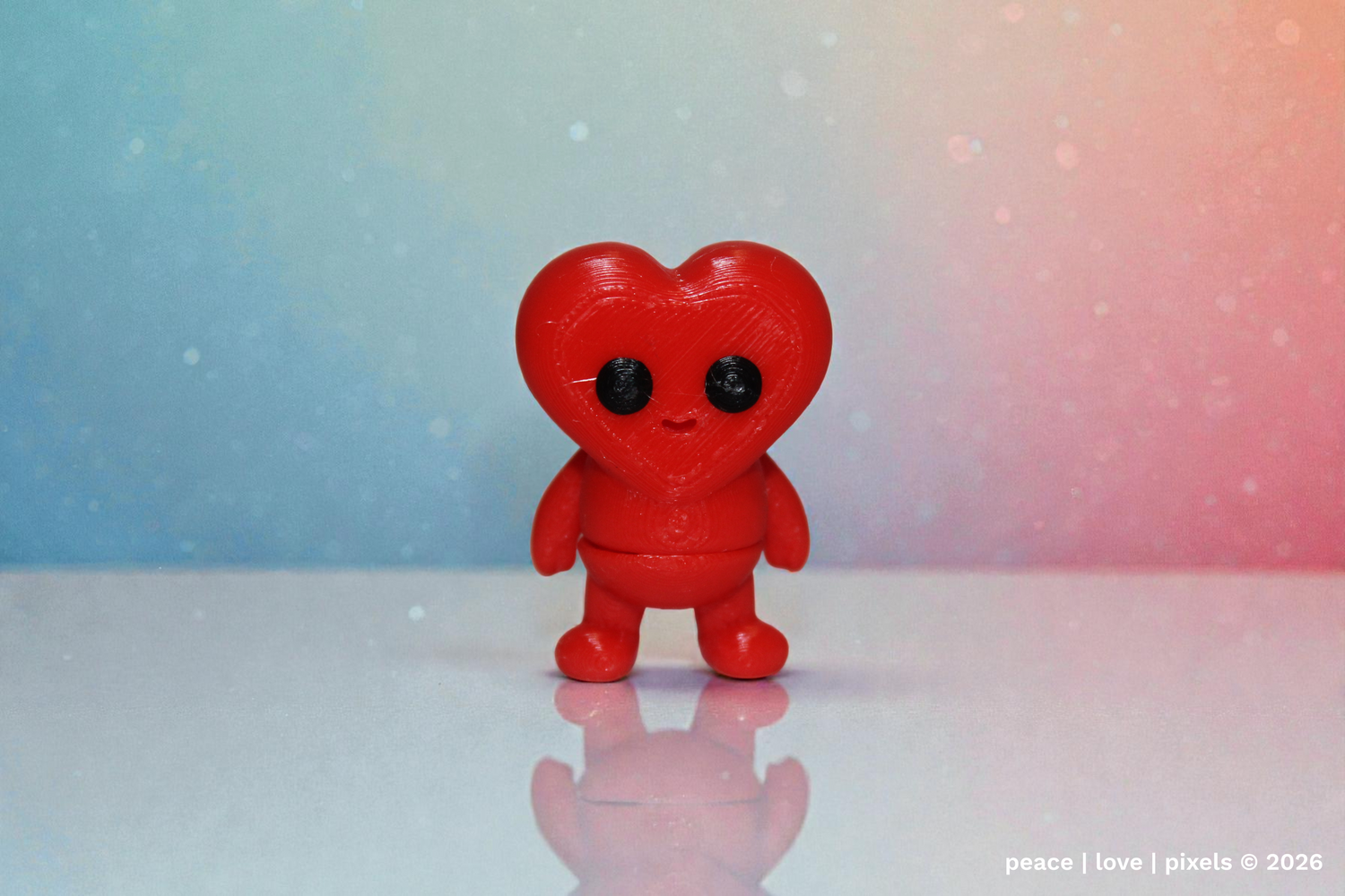 Red heart-shaped articulated figurine with black eyes on a gradient blue to pink background. 3D printed figurine in PLA material. Designer: ZOU3D. peace | love | pixels is an authorized seller for ZOU3D. https://www.instagram.com/zou3d